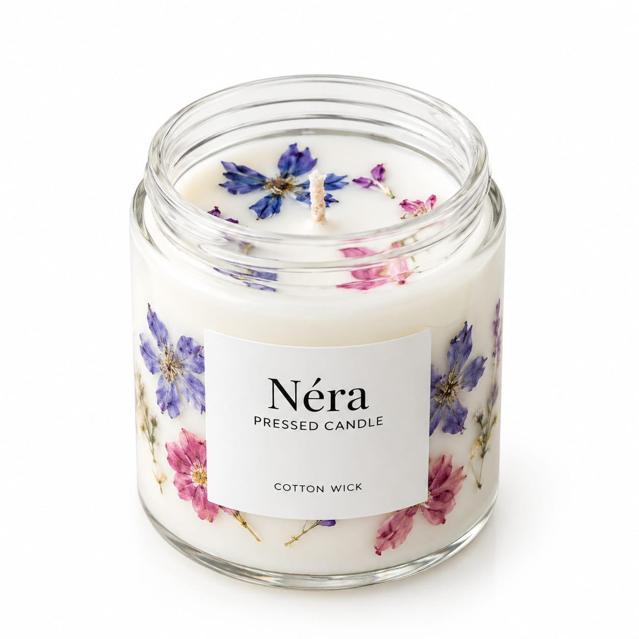 NÉRA Pressed candle in a clear glass jar with pressed flowers set into creamy wax and a thick cotton wick