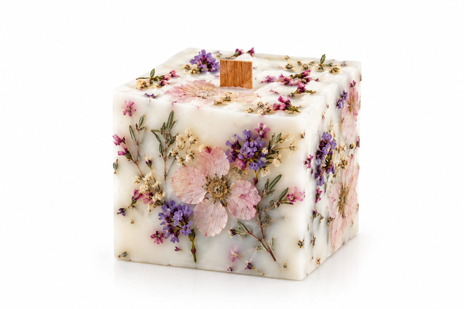 NÉRA Botanical Cube candle, a creamy cube-shaped pillar candle embedded with dried flowers and lavender sprigs, finished with a wide wooden wick