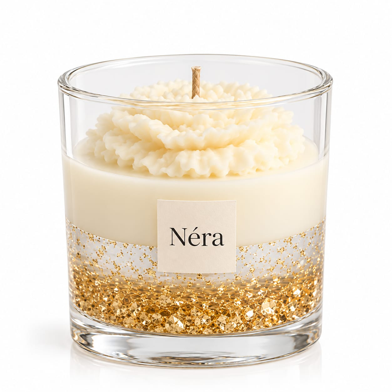 NÉRA Gold Blossom candle with a sculpted ivory flower top and shimmering gold flakes in a clear glass jar